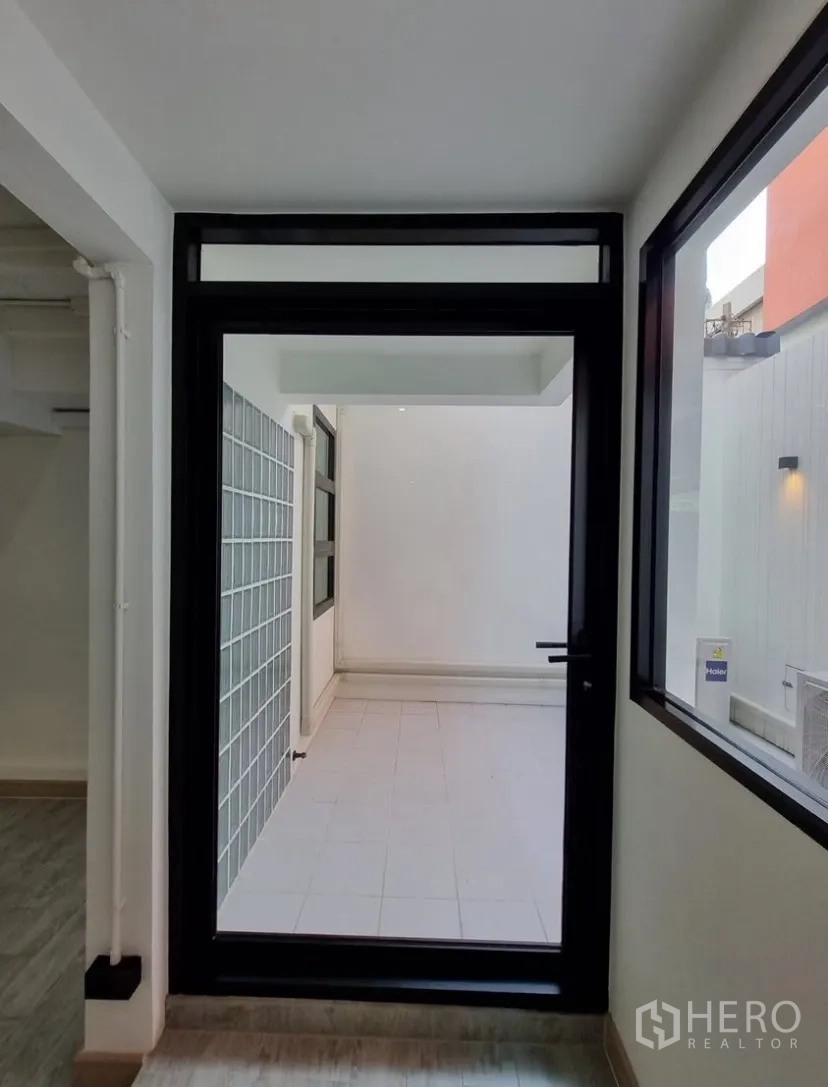 Detached House for rent in Suan Luang, Bangkok - Glass door opening to a small tiled courtyard with a glass-block wall.