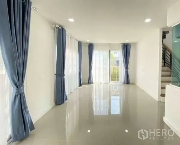 บ้าน ขายในBang Khen, Bangkok - โถงนั่งเล่นและทานอาหารพื้นกระเบื้องเงา หน้าต่างบานใหญ่พร้อมผ้าม่านสีน้ำเงิน