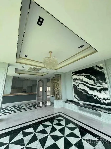 บ้าน ขายในMueang Nonthaburi, Nonthaburi - โถงรับแขกหรู โคมระย้า ผนังลายหินอ่อนขาวดำ และพื้นลายเรขาคณิตต่อเนื่องสู่ครัว