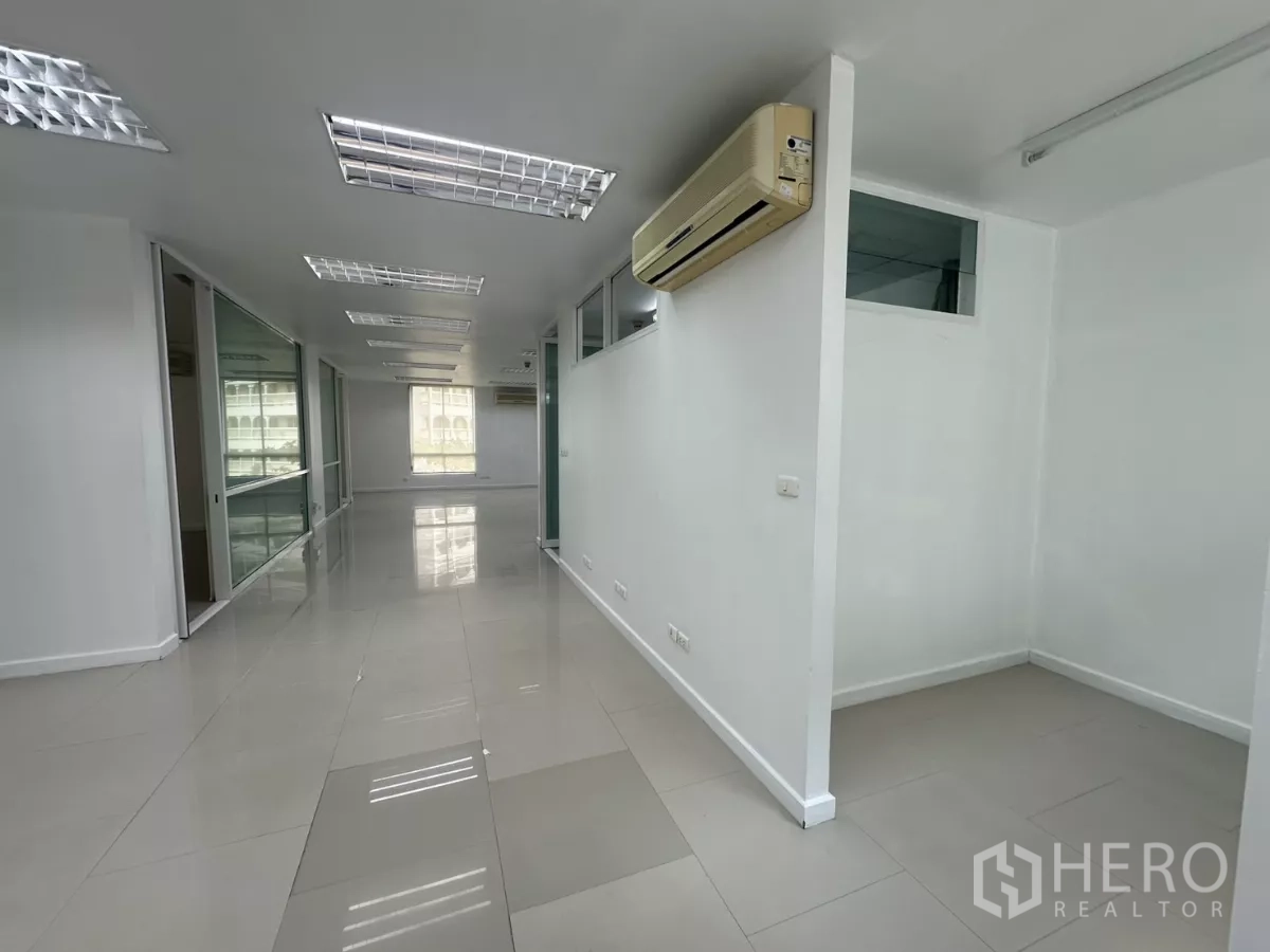 办公空间 出租在Huai Khwang, Bangkok - 明亮的开放式办公区，玻璃隔间、瓷砖地面、分体空调与日光灯。