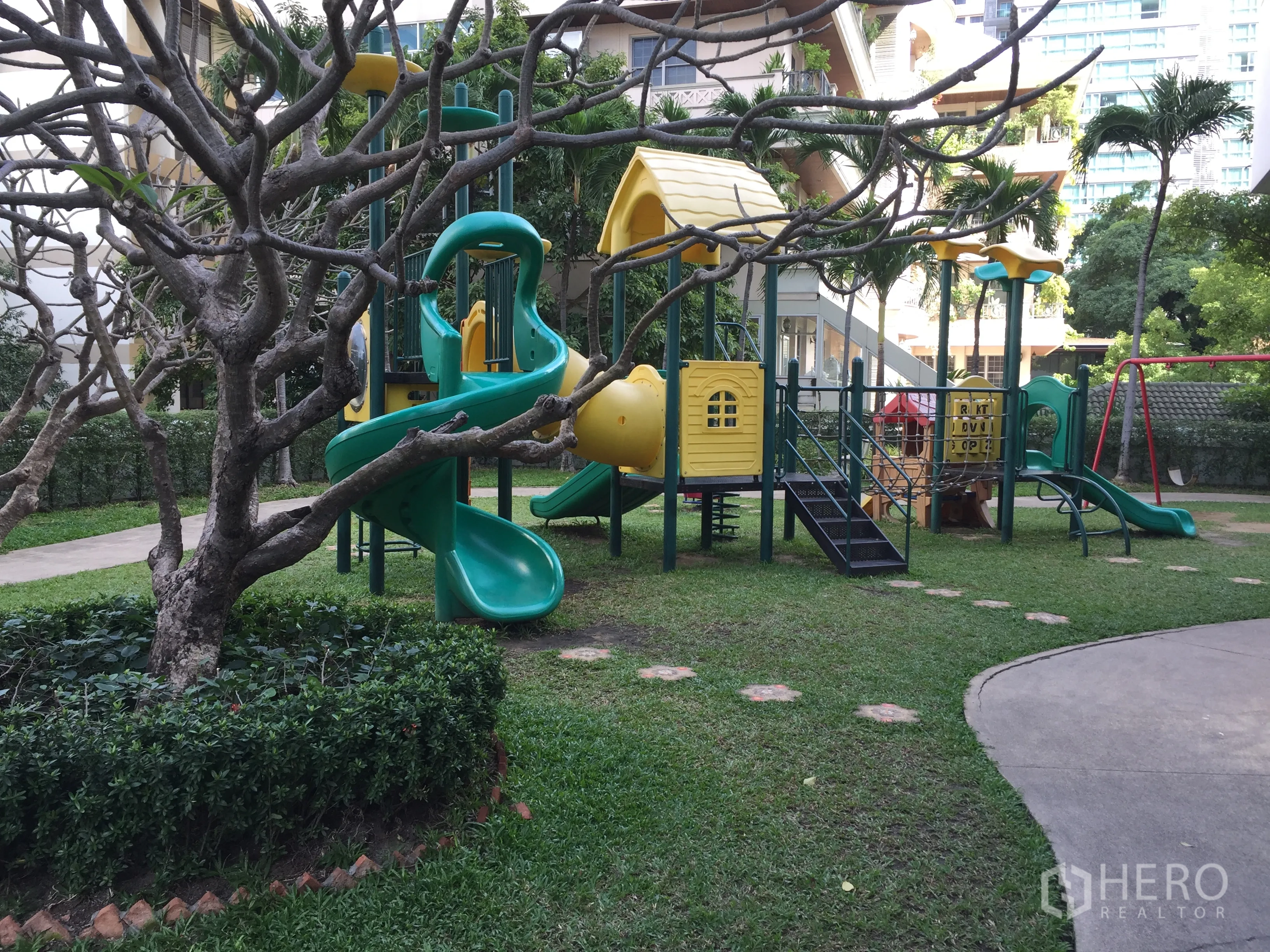 Condominium for rent in Watthana, Bangkok - Landscaped garden playground with colorful slides and climbing structures.