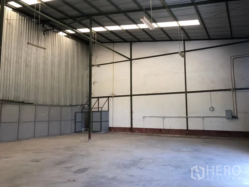 Warehouse for rent in Lat Krabang, Bangkok - High-ceiling warehouse interior in Lat Krabang, Bangkok with steel frame, skylights, concrete floor and visible electrical lines.
