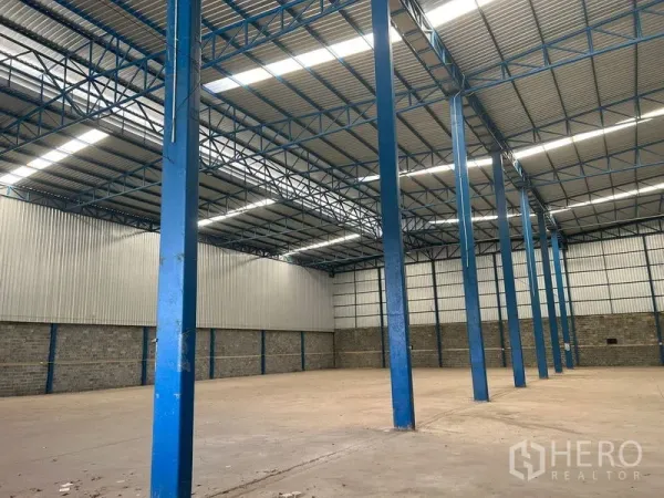คลังสินค้า ให้เช่าในLat Krabang, Bangkok - แถวเสาเหล็กสีน้ำเงินและสกายไลท์ภายในโกดังอุตสาหกรรม
