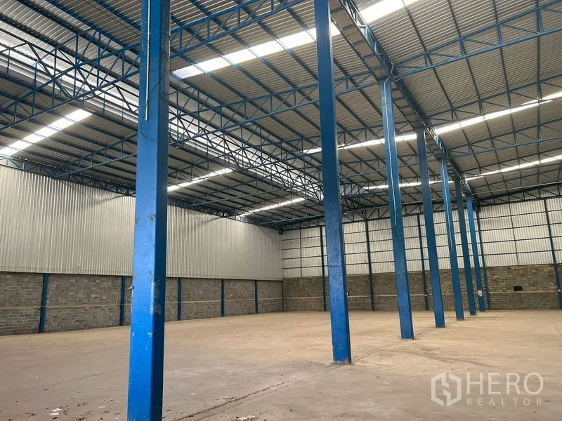 คลังสินค้า ให้เช่าในLat Krabang, Bangkok - แถวเสาเหล็กสีน้ำเงินและสกายไลท์ภายในโกดังอุตสาหกรรม