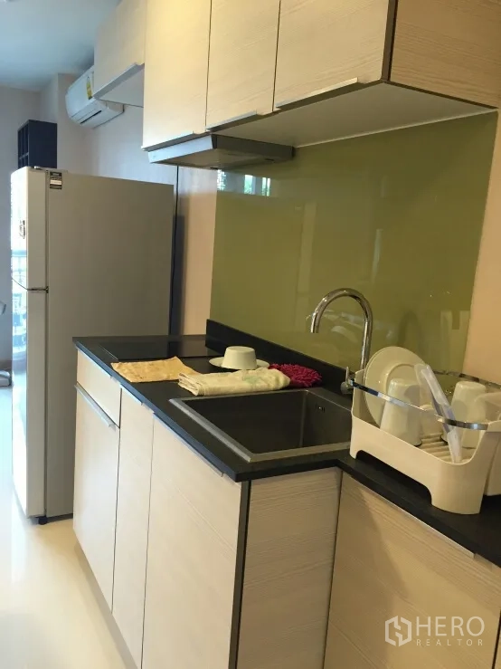 คอนโด ให้เช่าในWatthana, Bangkok - ครัวบิวต์อินตู้ลายไม้ เคาน์เตอร์สีดำ อ่างล้างจาน ผนังกระจก และตู้เย็น