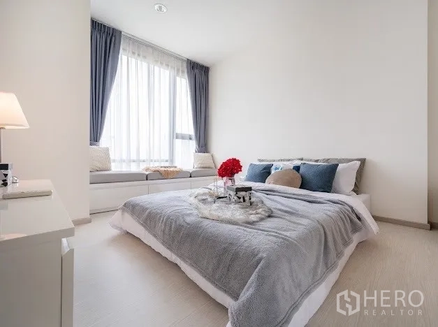 公寓 出售在Khlong Toei, Bangkok - 宽敞卧室，设飘窗座位与灰色床品，采光充足。