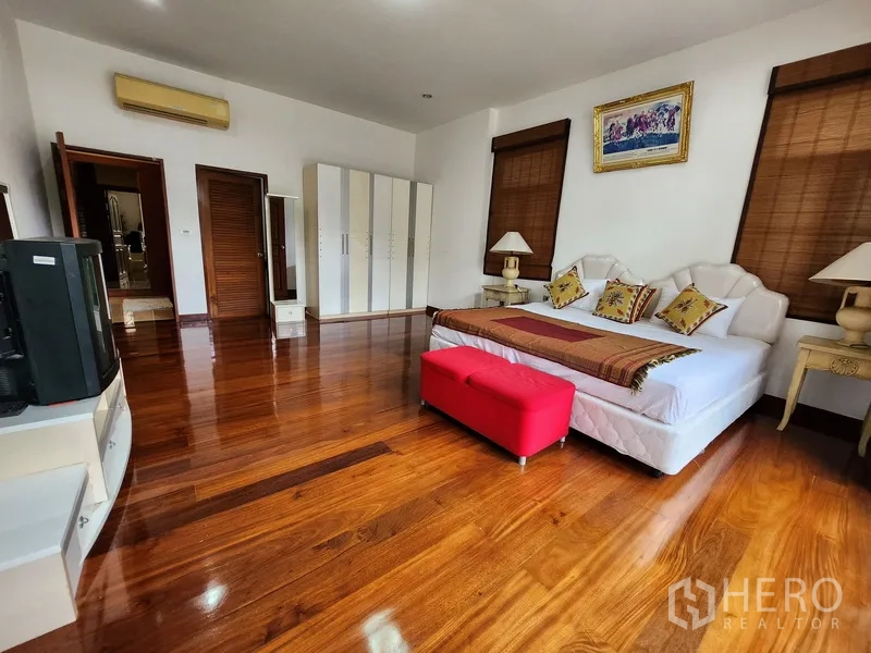 独立式住宅 出租在Prawet, Bangkok - 通透明亮的卧室，配大床、衣柜与光亮木地板。