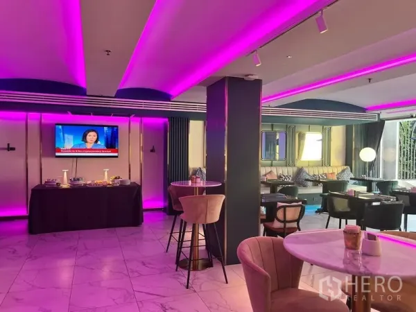 พื้นที่ขายปลีก ให้เช่า - เลานจ์พื้นที่ค้าปลีกร่วมสมัย ไฟ LED สีชมพู พื้นกระเบื้องหินอ่อน โต๊ะคาเฟ่ เก้าอี้บาร์ และผนังทีวี