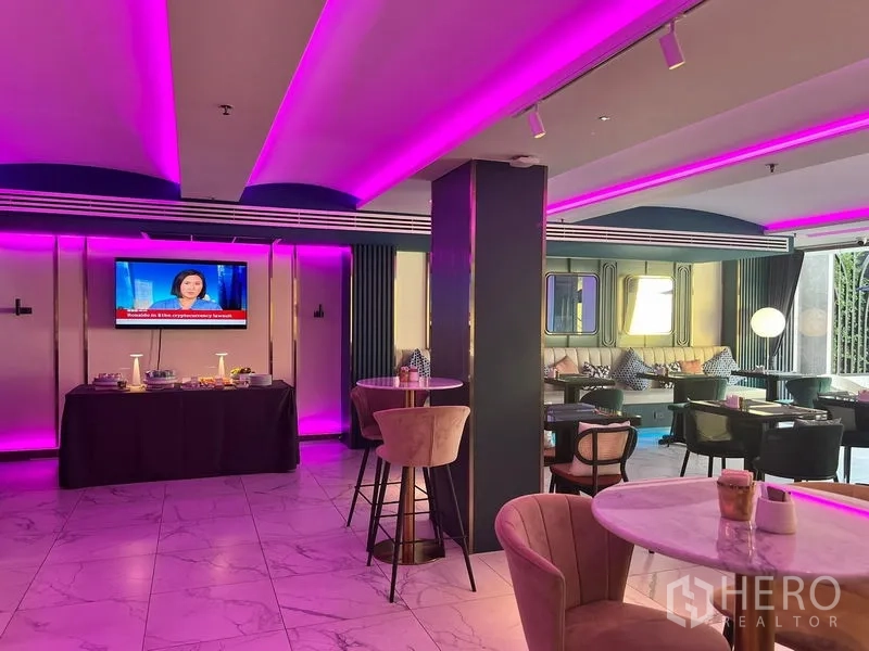 พื้นที่ขายปลีก ให้เช่า - เลานจ์พื้นที่ค้าปลีกร่วมสมัย ไฟ LED สีชมพู พื้นกระเบื้องหินอ่อน โต๊ะคาเฟ่ เก้าอี้บาร์ และผนังทีวี