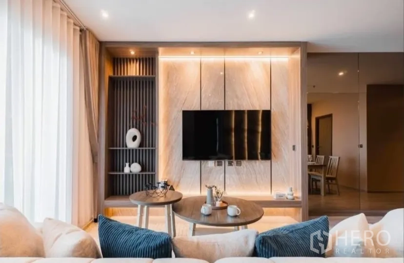 คอนโด for rent in Watthana, Bangkok - ห้องนั่งเล่นสไตล์ร่วมสมัยพร้อมชั้นบิลท์อินและผนังทีวีหินอ่อนมีไฟ