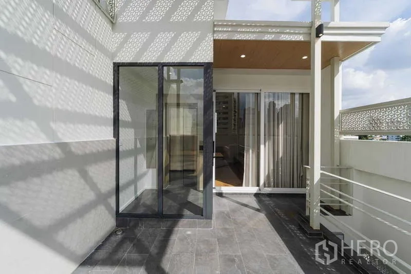 ทาวน์เฮาส์ ให้เช่าหรือขายในWatthana, Bangkok - เทอเรซดาดฟ้าพร้อมประตูกระจกสไลด์ วิวเมืองบางส่วน และหลังคาฉลุ