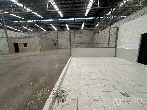 Warehouse for rent in Khlong Toei, Bangkok - Tiled service area with chain-link partitions next to the main warehouse floor.