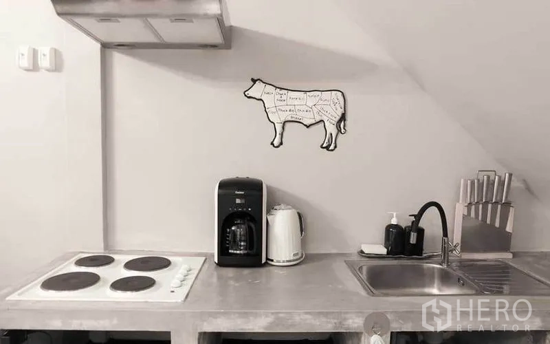 联排别墅 出租在Watthana, Bangkok - 极简水泥台面厨房，配电炉、水槽、咖啡机与烧水壶。