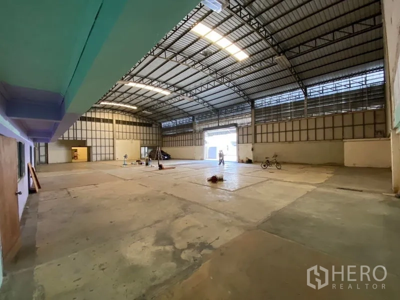 คลังสินค้า ให้เช่าในBueng Kum, Bangkok - ฮอลล์โกดังโปร่ง เพดานทรัสสูง แผ่นรับแสงธรรมชาติ และประตูโรลเลอร์ขนาดใหญ่สำหรับขนถ่าย