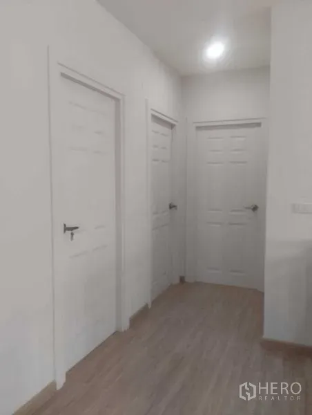 บ้าน ขายในPhra Khanong, Bangkok - โถงภายในบ้านสว่าง มีประตูสีขาวสามบานและพื้นลายไม้