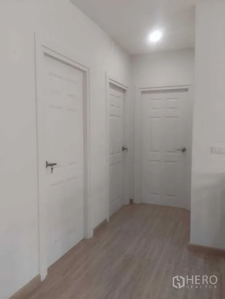 บ้าน ขายในPhra Khanong, Bangkok - โถงภายในบ้านสว่าง มีประตูสีขาวสามบานและพื้นลายไม้