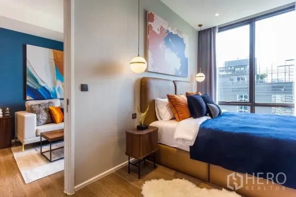 คอนโด ให้เช่าหรือขายในPathum Wan, Bangkok - ห้องนอนติดประตูบานเลื่อนเชื่อมห้องนั่งเล่น หน้าต่างสูงและโคมแขวน ในคอนโดกรุงเทพฯ