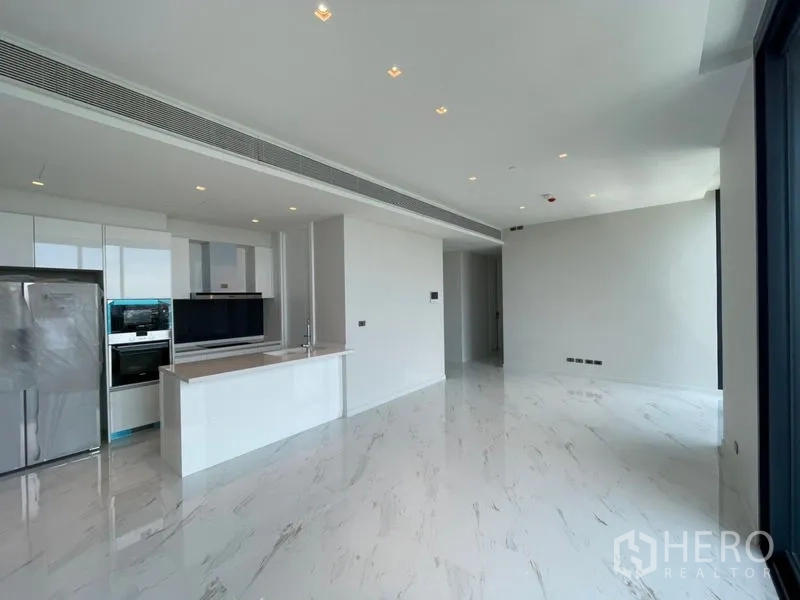 Condominium for rent or sale in Bangkok - Open-plan living area with glossy marble-look flooring, built-in kitchen and recessed lighting.