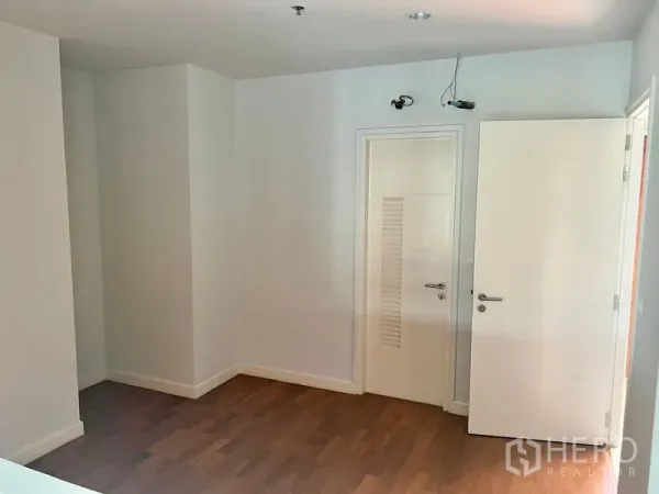 คอนโด ให้เช่าในBang Kho Laem, Bangkok - ห้องนอนโล่งพื้นไม้ ผนังสีขาว พร้อมประตูสีขาวดีไซน์โมเดิร์น