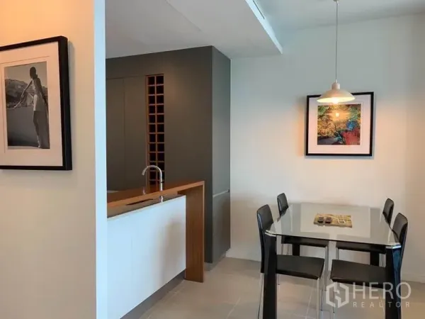 คอนโด ให้เช่าในKhlong San, Bangkok - มุมรับประทานอาหารมีโคมไฟแขวน ข้างครัวกะทัดรัดและภาพแขวนผนัง