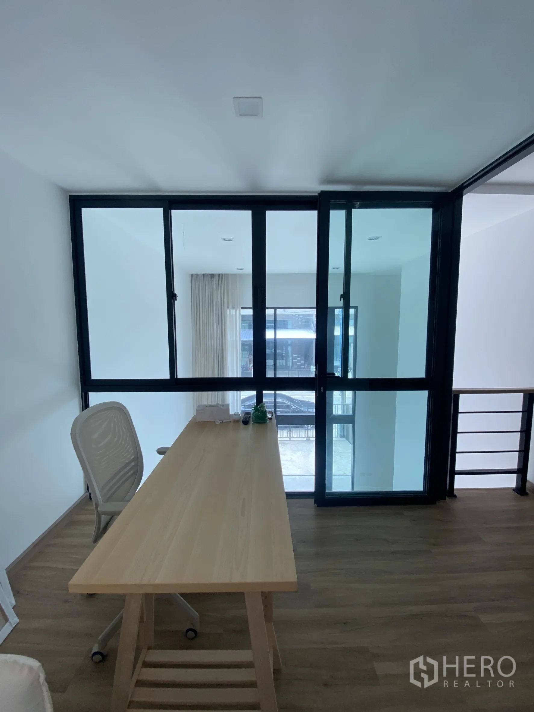 Townhouse for rent or sale in Bang Khae, Bangkok - Mezzanine home office with long wooden desk and glass sliding partition