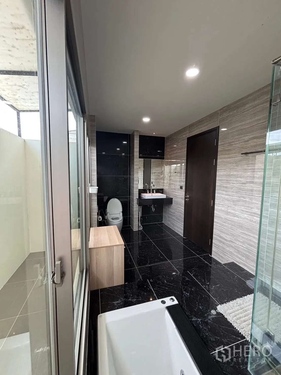 Detached House for rent in Bang Phli, Samut Prakan - Spacious bathroom with black marble-style tiles, bathtub and glass shower.