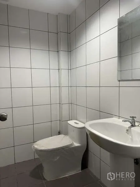 工厂 出租或出售在Bang Bua Thong, Nonthaburi - 干净的瓷砖卫生间，坐便器与洗手盆。