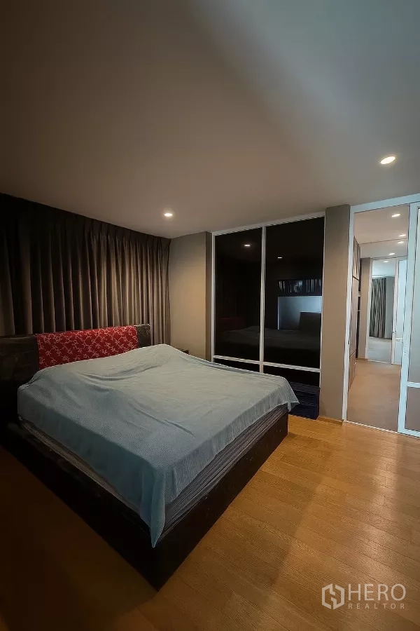 Detached House for sale - Spacious master bedroom with king bed, hardwood floors, and glass-door wardrobe.