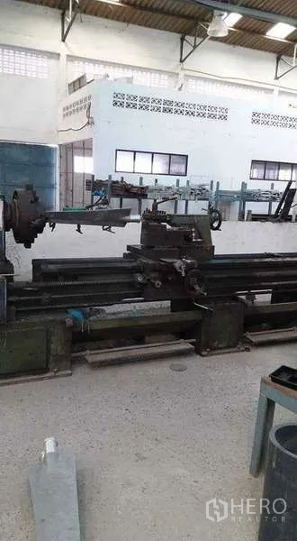 Warehouse for rent or sale in Nong Suea, Pathum Thani - Long metal lathe positioned in a bright workshop.