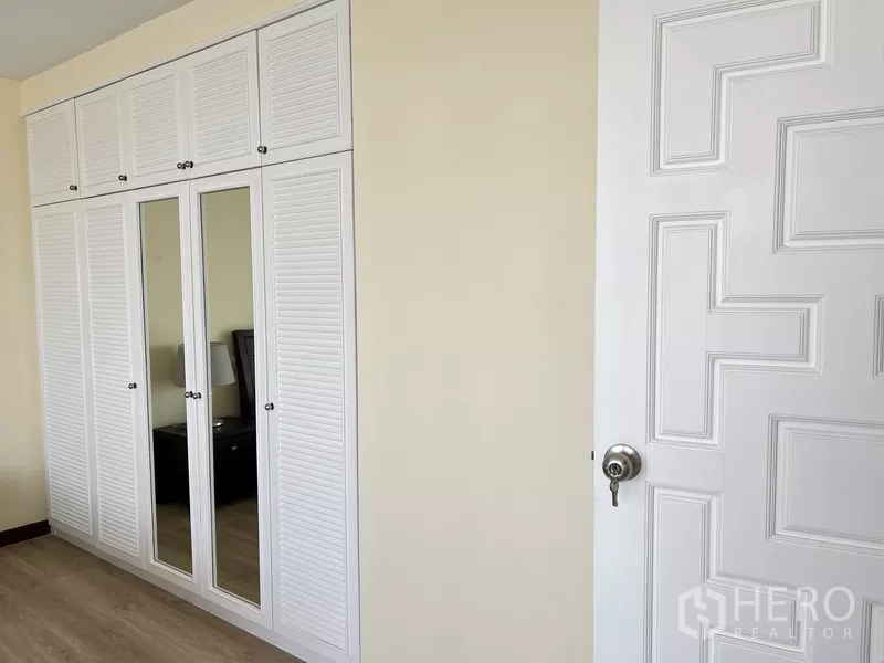 คอนโด ให้เช่าในKhlong Toei, Bangkok - ผนังห้องนอนมีตู้เสื้อผ้าบิวท์อินสีขาวบานสูงพร้อมกระจกเงา