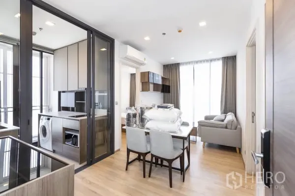 คอนโด ให้เช่าในPhaya Thai, Bangkok - พื้นที่นั่งเล่นและรับประทานอาหารสว่าง โปร่ง พร้อมครัวกั้นกระจก เครื่องซักผ้า และหน้าต่างบานใหญ่ในคอนโดพญาไท