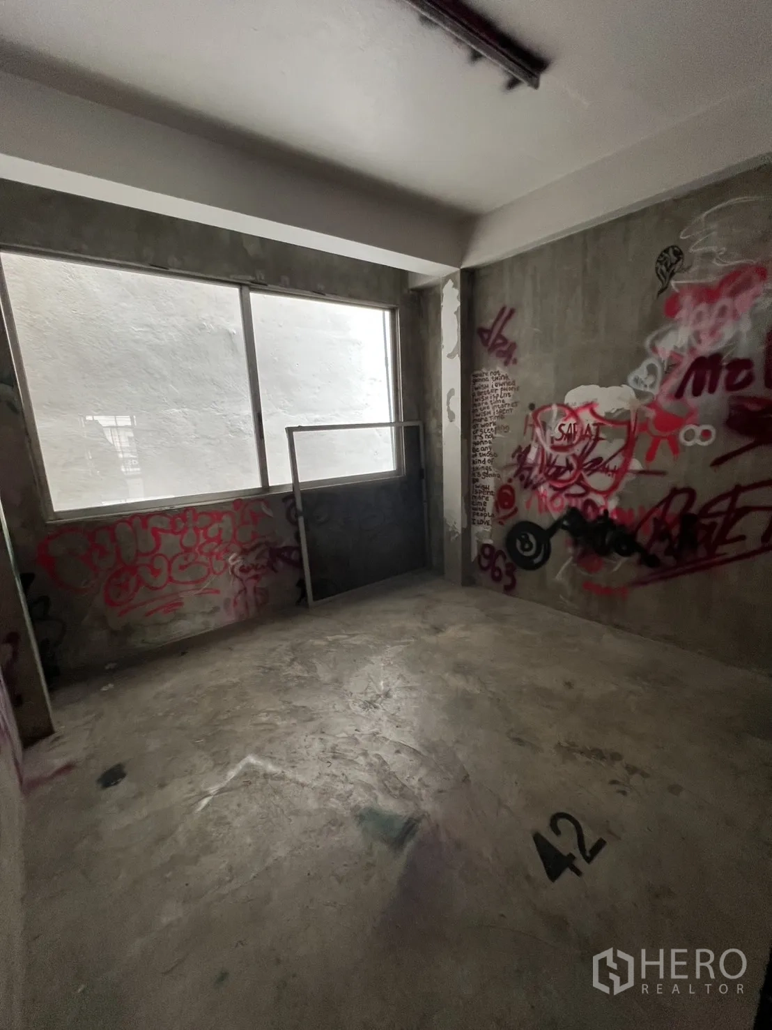店屋 出租在Watthana, Bangkok - 半成品房间，水泥墙上有涂鸦，大窗采光。