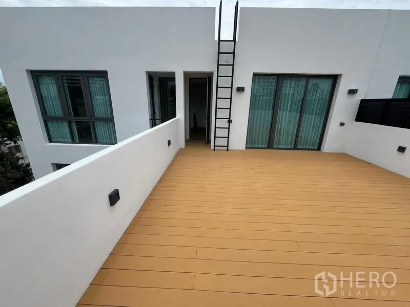 ทาวน์เฮาส์ ให้เช่าในKhlong Toei, Bangkok - ดาดฟ้ากว้างปูพื้นไม้ พร้อมบันไดปีนและประตูกระจกบานเลื่อน