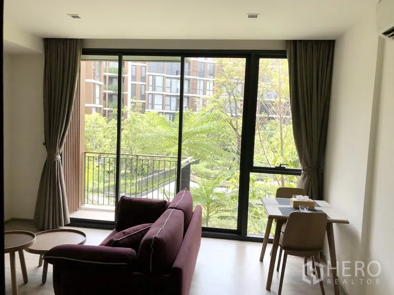 คอนโด ให้เช่าในWatthana, Bangkok - มุมนั่งเล่นและโต๊ะทานอาหาร เปิดสู่ระเบียงที่มองเห็นสวนส่วนกลาง