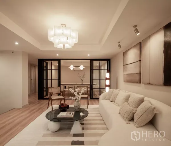 带办公室的家 出售在Phra Khanong, Bangkok - 温馨客厅，弧形沙发、玻璃隔断与现代灯光。