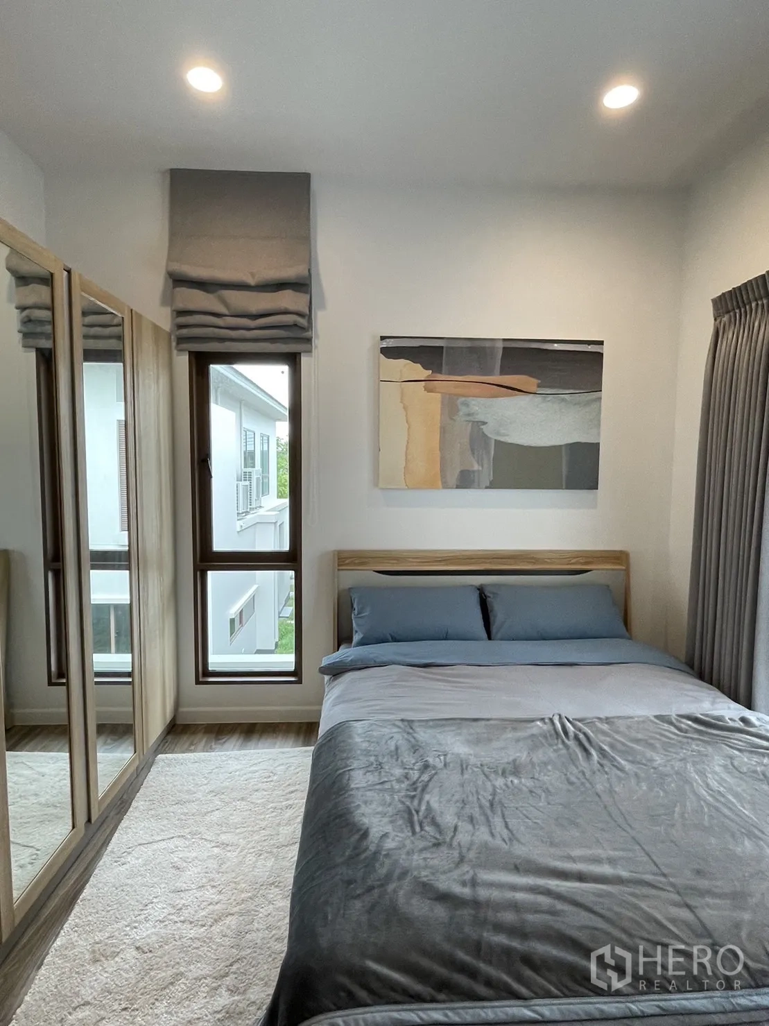 Detached House for rent in Bang Kapi, Bangkok - Bright bedroom with mirrored wardrobe and corner windows.