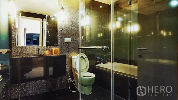 คอนโด ให้เช่าหรือขายในKhlong Toei, Bangkok - ห้องน้ำสไตล์โมเดิร์น มีกระจกกั้นอาบน้ำ อ่างอาบน้ำ กระเบื้องโทนเข้ม และกระจกเงาบานใหญ่