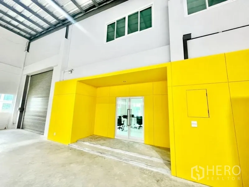 คลังสินค้า ขายในLam Luk Ka, Pathum Thani - ทางเข้าออฟฟิศสีเหลืองภายในโกดัง พร้อมประตูกระจกและชั้นลอย