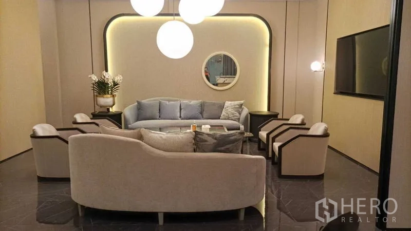 零售空间 出租 - 主客厅布局，沙发围绕茶几，背光墙与圆镜点缀。