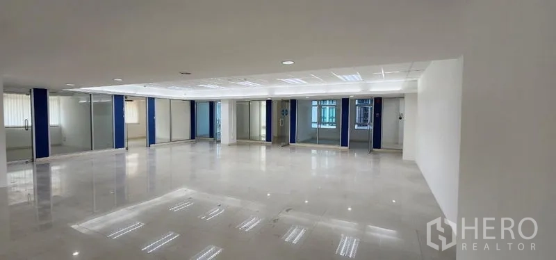 Office Space for rent in Chatuchak, Bangkok - Large office floor with polished tiles and a full row of glass-fronted private rooms.