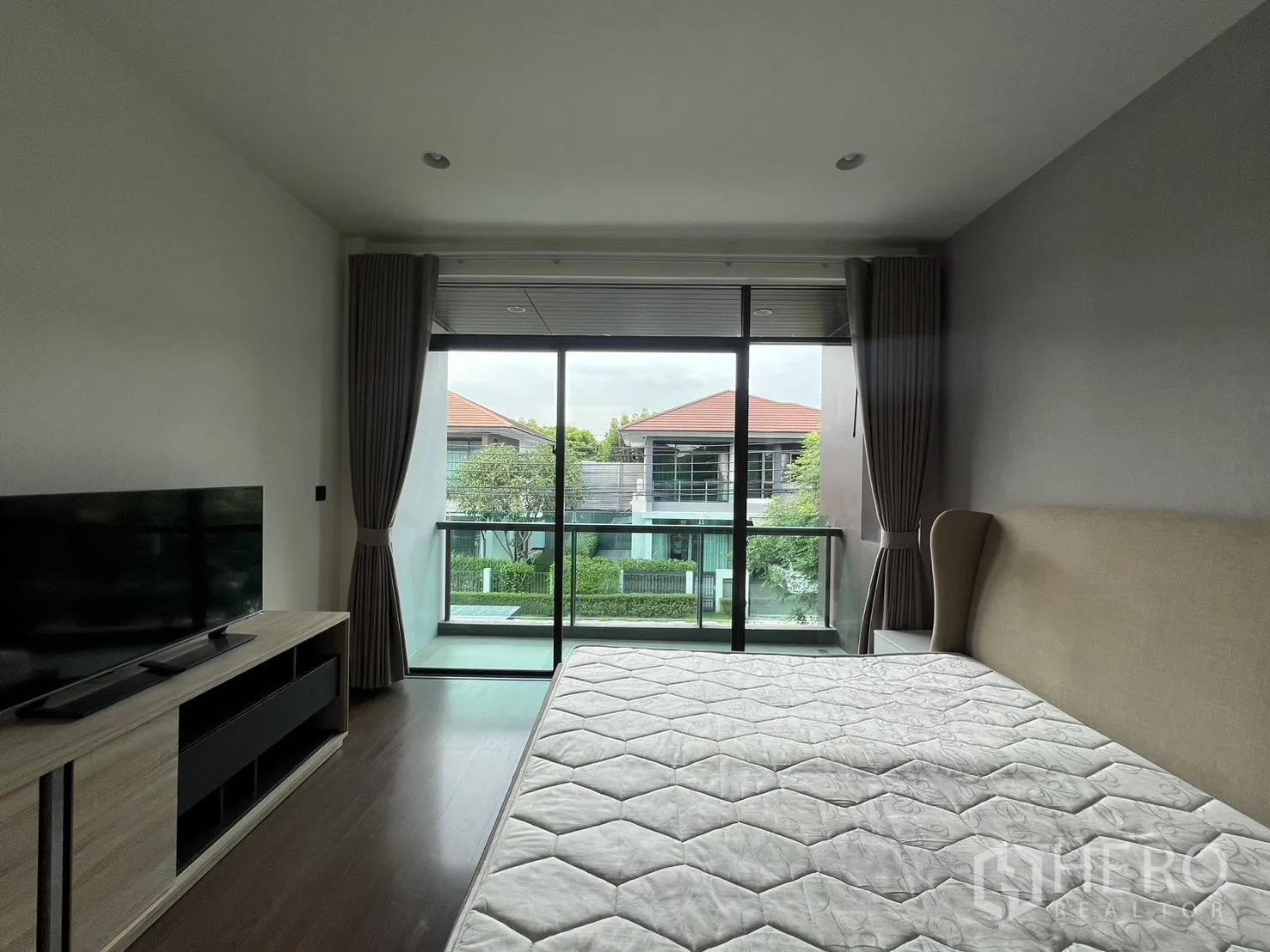 บ้าน ให้เช่าในBang Kapi, Bangkok - ห้องนอนใหญ่ มีระเบียง เตียง และชั้นวางทีวี