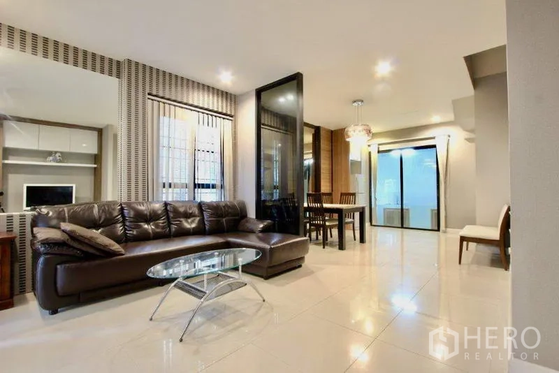 ทาวน์เฮาส์ ขายในSuan Luang, Bangkok - พื้นที่รับแขกและรับประทานอาหารแบบโอเพ่น พร้อมโซฟาหนังและโต๊ะกระจก