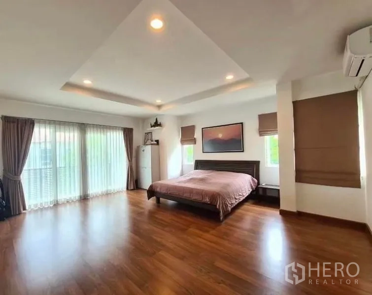 บ้าน ให้เช่าหรือขายในLat Krabang, Bangkok - ห้องนอนหลักกว้าง พื้นไม้ ฝ้าหลุมดาวน์ไลท์ และหน้าต่างบานใหญ่