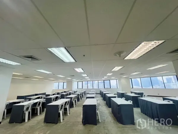 สำนักงาน ให้เช่า - ห้องจัดแบบคลาสรูม ใต้ฝ้าแบบกริดพร้อมไฟฟลูออเรสเซนต์ และหน้าต่างกว้างเต็มผนัง.