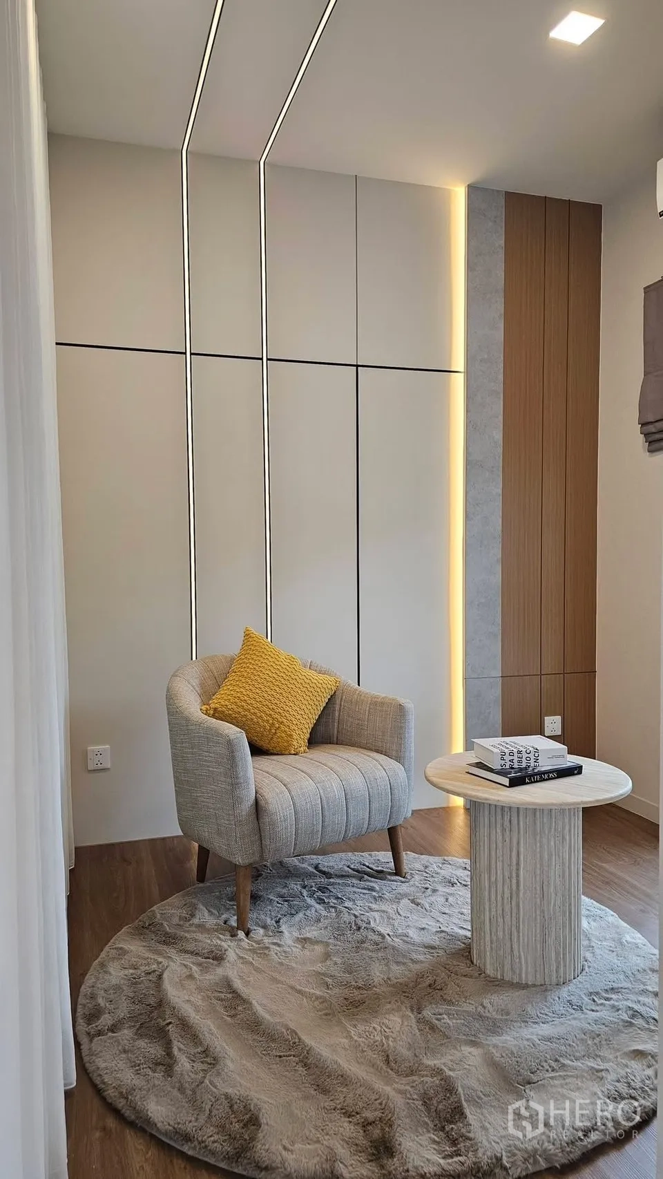 บ้านเดี่ยว for rent in Bang Phli, Samut Prakan - มุมนั่งพักผ่อนมีเก้าอี้บนพรมฟูนุ่ม และโต๊ะข้าง ข้างผนังไฟซ่อน.