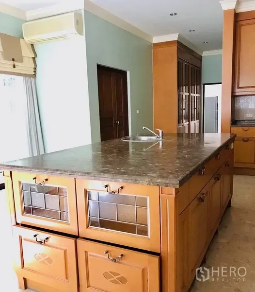 บ้าน ให้เช่าหรือขายในBang Na, Bangkok - ห้องครัวพร้อมไอส์แลนด์ท็อปหินและตู้ไม้ในบ้านเดี่ยวบางนา