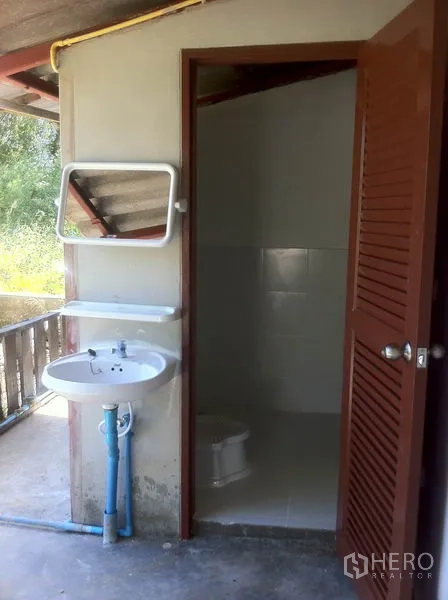 货栈 出租在Lam Luk Ka, Pathum Thani - 简洁卫生间，配有镜子、洗手盆与马桶。