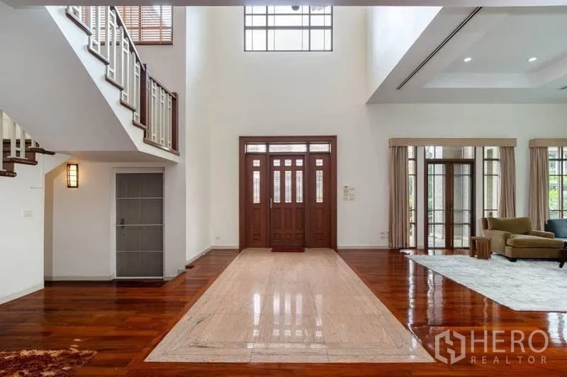 บ้าน ให้เช่าหรือขายในWatthana, Bangkok - โถงทางเข้าโอ่อ่า ประตูไม้คู่ เพดานสูงสองชั้น แสงธรรมชาติเต็มพื้นที่