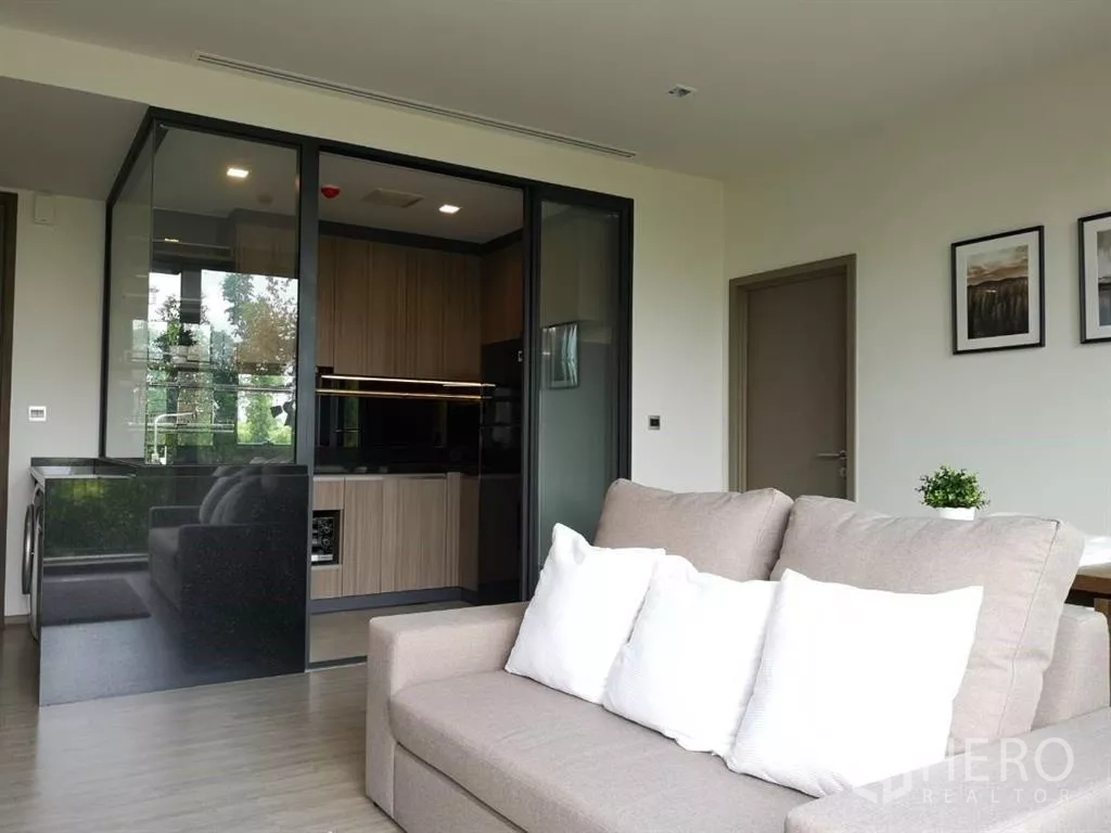 คอนโด ให้เช่าในWatthana, Bangkok - มุมห้องนั่งเล่นมองเห็นครัวปิด เคาน์เตอร์หินสีดำและเครื่องใช้บิวท์อิน