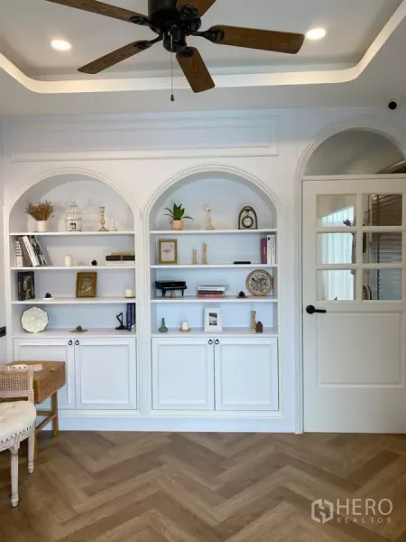 独立式住宅 出售在Sai Mai, Bangkok - 明亮房间内设白色拱形一体书柜与吊扇。